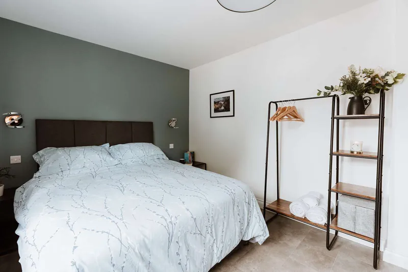 The Severn Room: king-size bed against a soft sage wall with reading lights either side